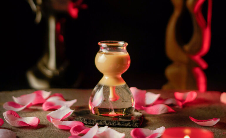 Two layers cocktail with Irish cream inside a shot glass around flowers