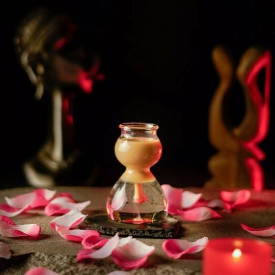 Shot Glass with slippery nipple cocktail inside and roses red background