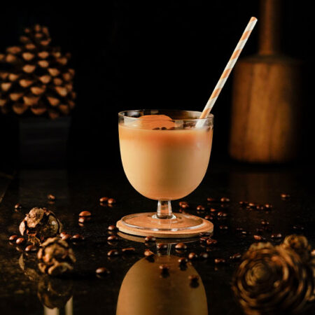 White russian cocktail inside a cocktail glass with a small stem and a large body