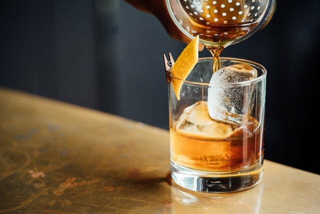 Whisky Old Fashioned being poured into a short glass