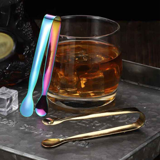 Round Head Tong Rainbow and Gold next to drink