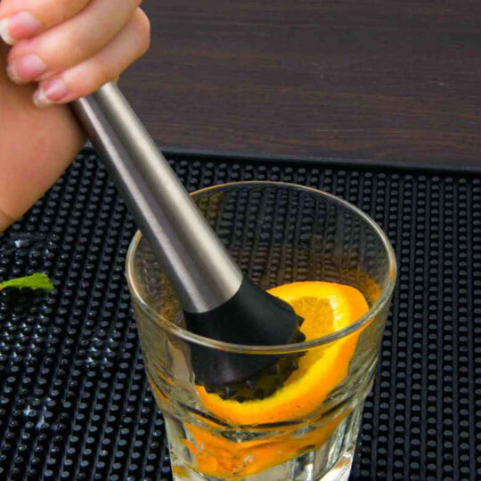 Sharp Teeth Muddler muddling an orange slice inside a glass