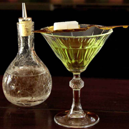 Sugar cube dissolving on top of the Hollowed Absinthe Spoon into a glass