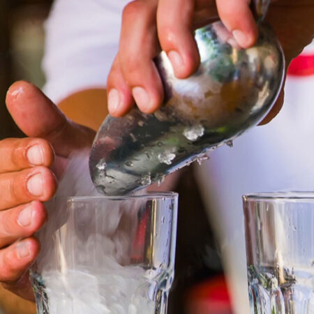 Bartender Handling Stainless Steel Ice scoop pouring into a glass