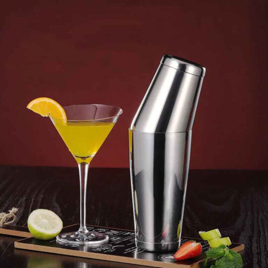 Silver stainless steel Boston cocktail shaker next to a Martini glass