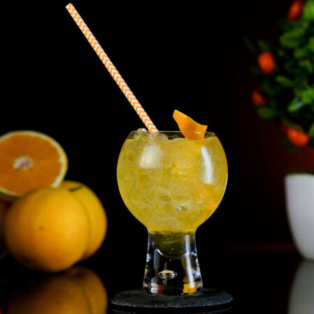 Bubble Cocktail Glass Full with an orange cocktail