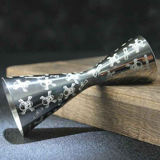 Engraved stainless steel cocktail jigger with a skull design
