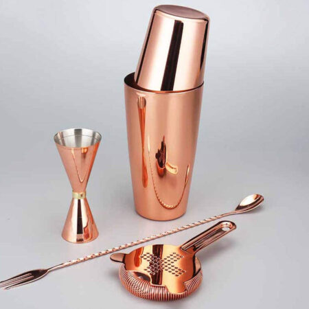 Four piece copper plated stainless steel cocktail bartending set of a Boston Shaker and a Hawthorne Strainer and a Bar Spoon and a Jigger