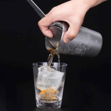 Engraved Stainless Steel Tin straining a cocktail into a glass