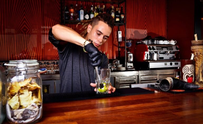 Bartender Muddling Lemons Inside Mixing Glass Using Muddler