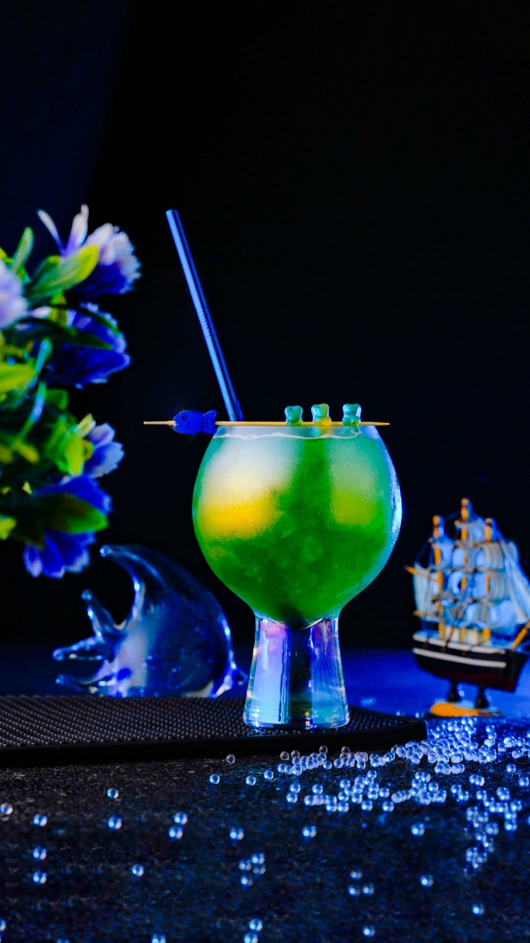 Green looking cocktail inside an exquisite glass around a blue lighted background