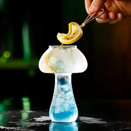 Mushroom-shaped glass with blue cocktail and lemon garnish, perfect for creative drink presentations.