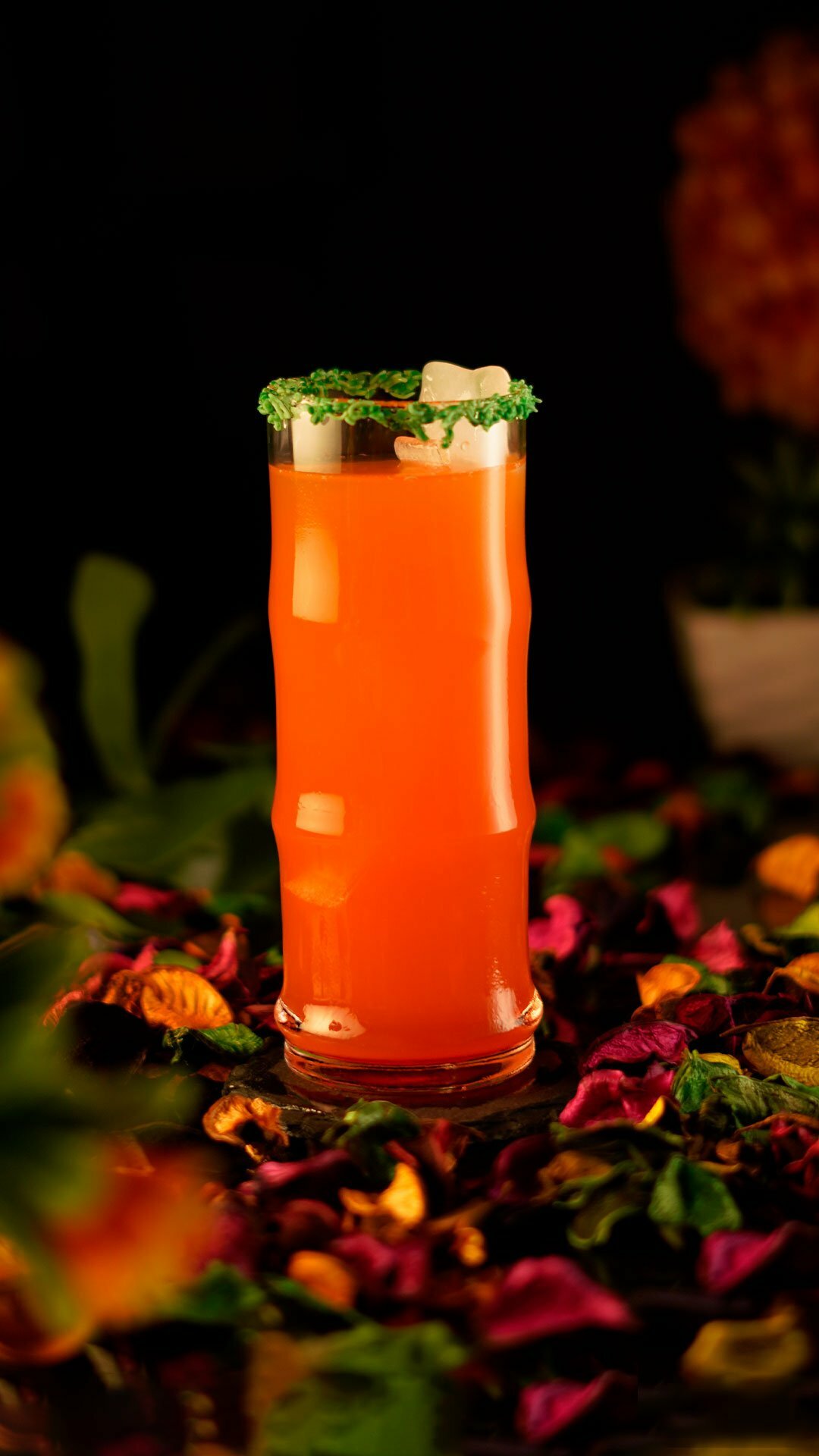 Orange exotic cocktail in an edged collins glass garnished with green sprinkles