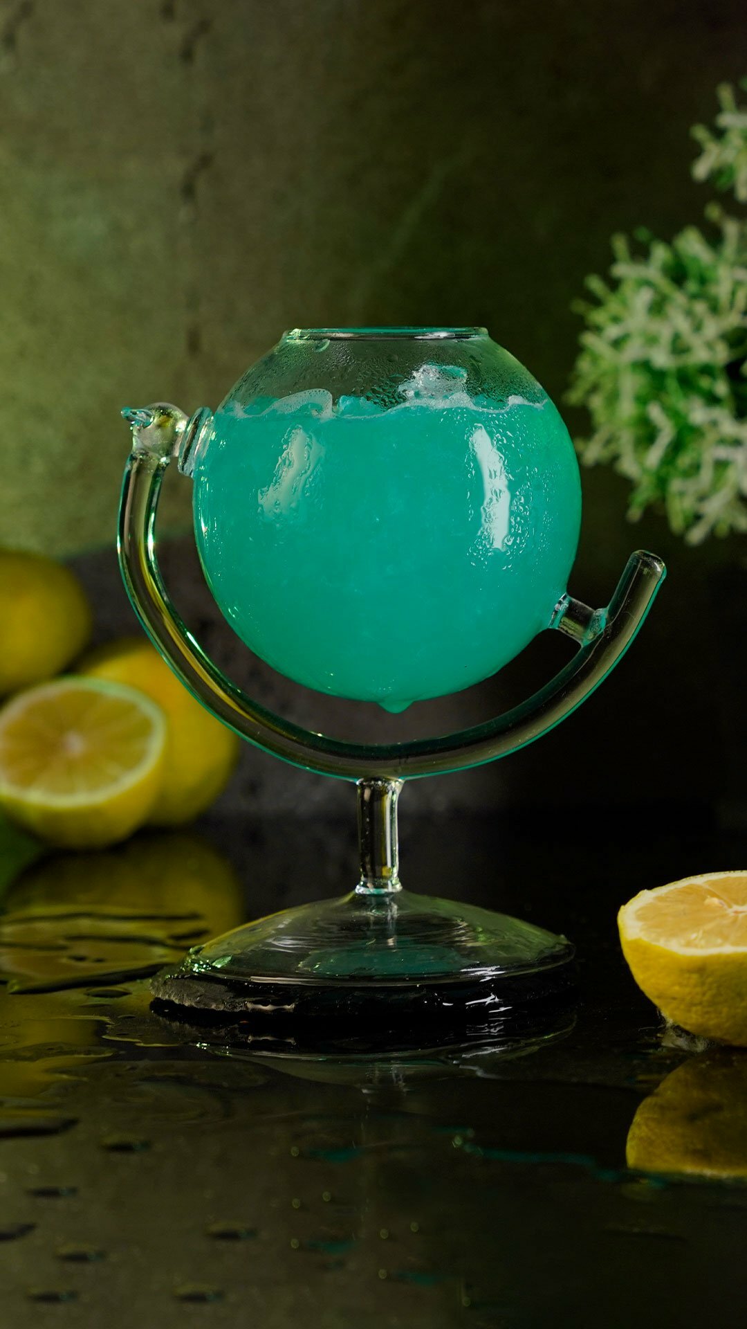 Blue cocktail inside a globe cocktail glass