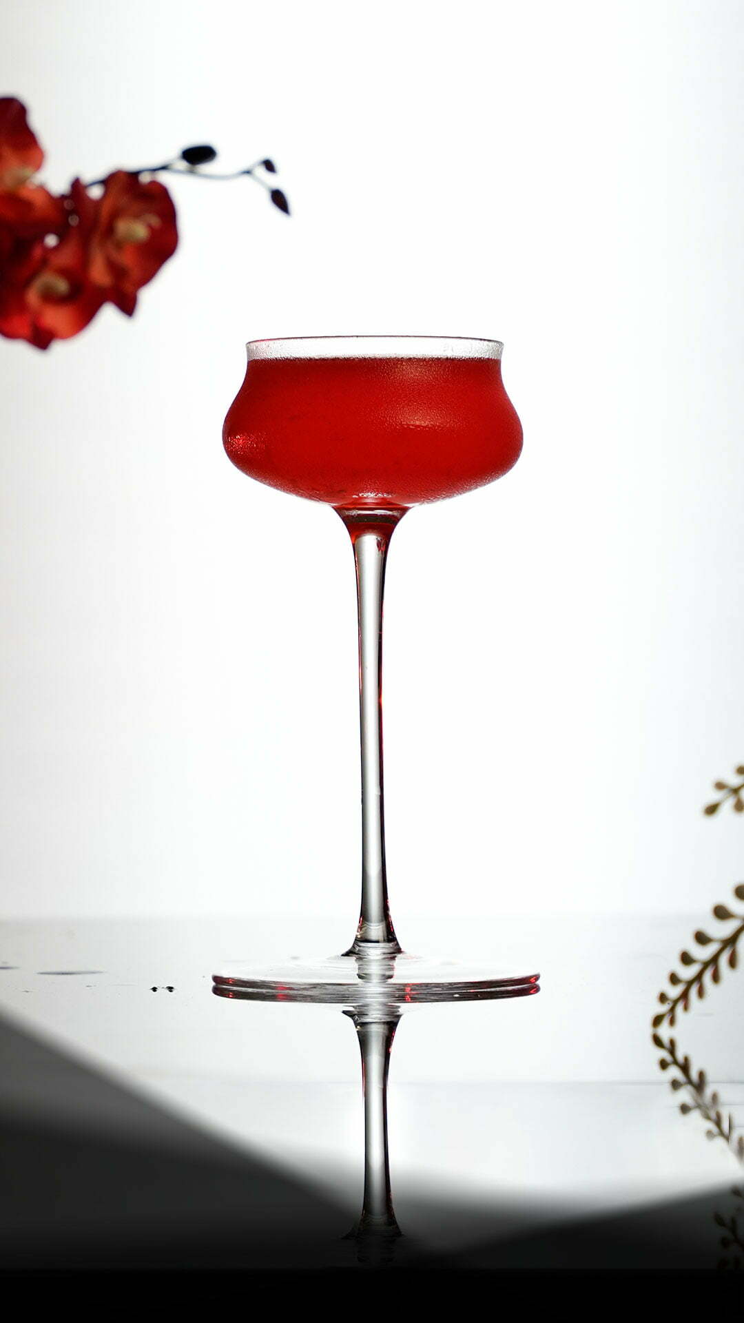 Red Cocktail inside a Tall Stemmed Coupe Glass