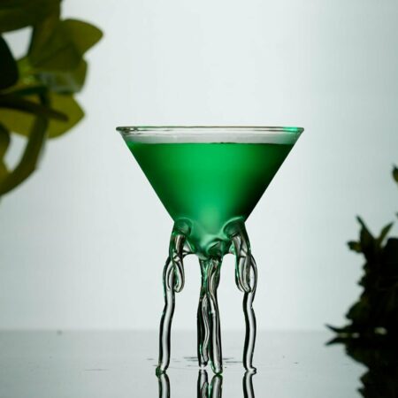 Exquisite octopus like cocktail martini glass filled with green cocktail