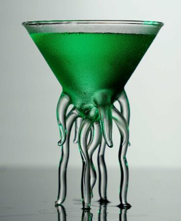 Green Cocktail inside a tiny martini glass with octopus legs