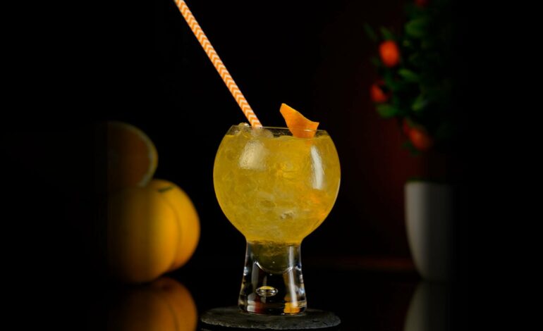 Orange Mixed Cocktail served in a rounded bubbly cocktail glass