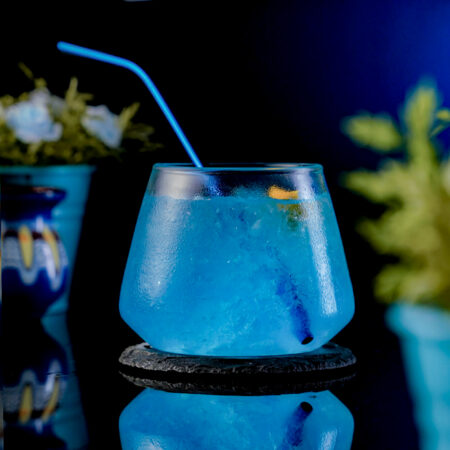 Short Unique Cocktail Glass Full with a blue cocktail