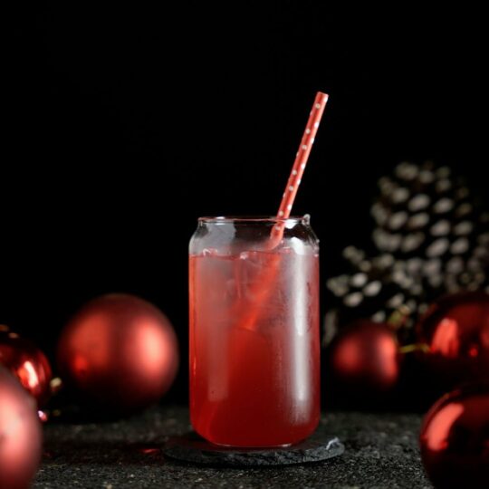 Red Cocktail in a glass jar around a Christmas background