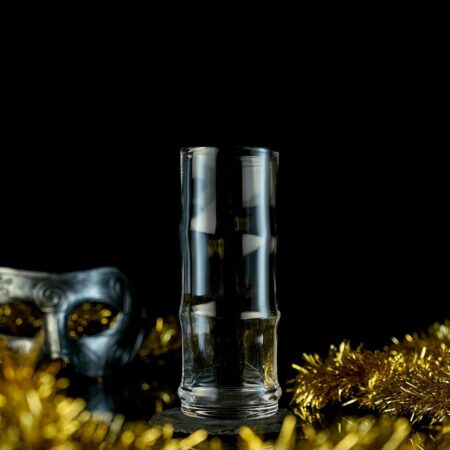 Empty Long Collins glass around New Years Celebration background