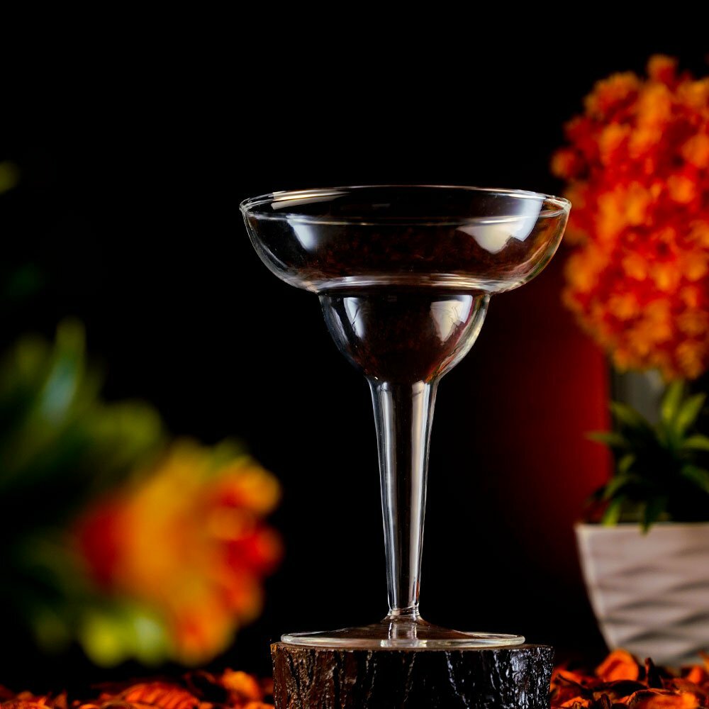 Empty Margarita Glass around a dark orange background