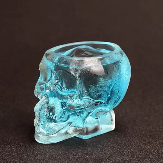 Transparent blue Grim Reaper Glass in the shape of a human skull, perfect for serving dramatic cocktails or as Halloween drinkware.