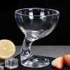 Clear cocktail glass with a unique spiral design, perfect for cocktails, shown with lemon slice and strawberries on a dark surface.