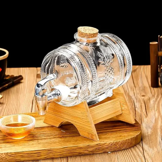 A transparent, red-tinted glass beverage dispenser with a pineapple design, mounted on a wooden stand with a tap at the front.