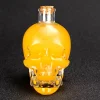 Clear glass skull-shaped Grim Reaper Bottle filled with yellow liquid, featuring detailed facial features and a cork stopper, perfect for storing spirits and themed events.