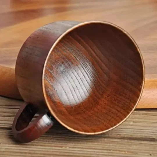 Handmade wooden cocktail mug by Skol, The Woodland Warmer, with visible grain, lying on its side, ideal for eco-friendly hot cocktails.