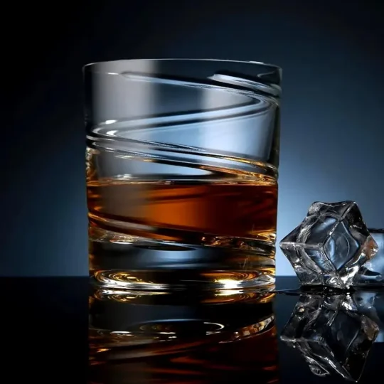 Horizon whisky glass with a short, wide base and horizontal ridges, filled with amber-colored liquid and ice cubes.