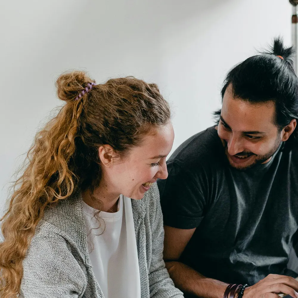 Two individuals laughing and happy with the products they just received, showcasing the assurance and joy of premium drinkware backed by a 100% satisfaction guarantee.