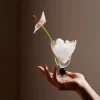 A hand holding the Obsidian Sphere Whisky Glass filled with ice cubes and topped with a white flower, featuring a distinctive black-beaded stem