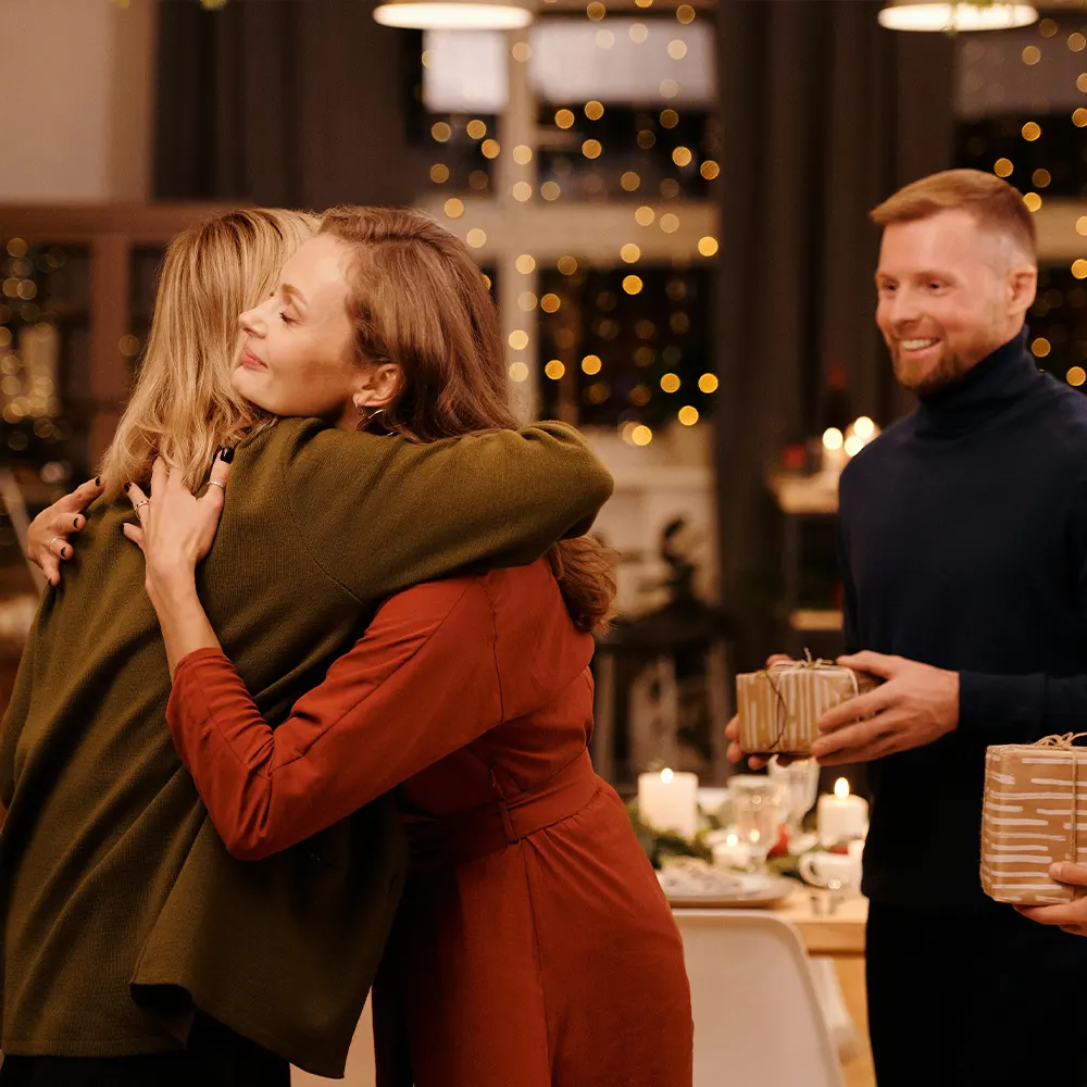 Three individuals enjoying an intimate gathering with a city nightscape in the background, highlighting the versatility of premium drinkware for various celebrations.