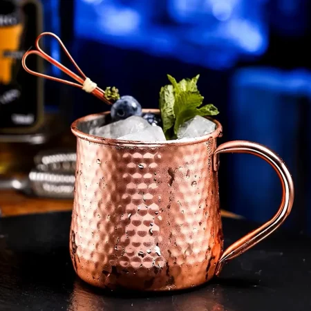 Hammered texture copper-plated stainless steel Moscow Mule mug with ice, mint, and blueberry garnish, 500 ml capacity.