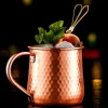 Hammered texture copper-plated stainless steel Moscow Mule mug with ice, mint, lime garnish, and cocktail stirrer, 500 ml capacity.