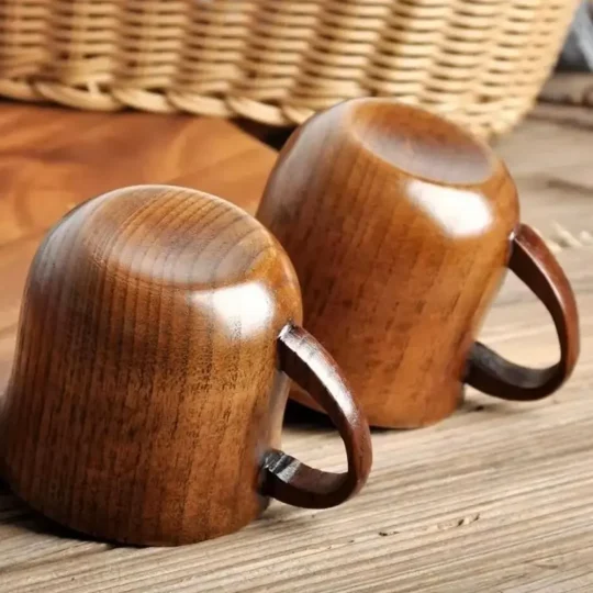 Pair of rustic wooden cocktail mugs by Skol, The Woodland Warmer, placed upside down, showcasing visible grain and eco-friendly design.