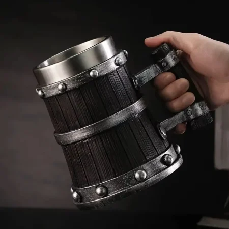 Hand holding the Viking Tankard, highlighting its barrel-shaped design with dark wooden staves and silver metal rings, perfect for medieval-themed gatherings.