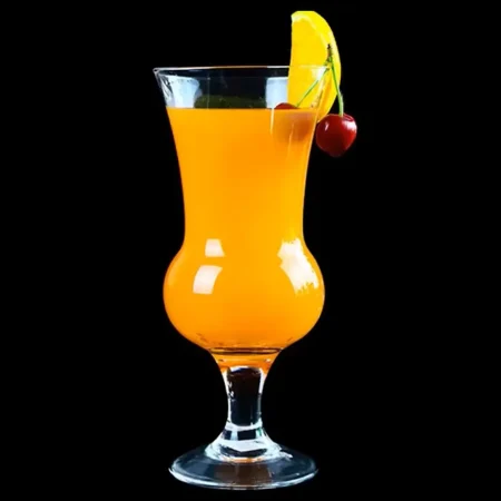 A 660 ml round belly cocktail glass filled with an orange cocktail, garnished with a slice of lemon and a cherry, against a black background.