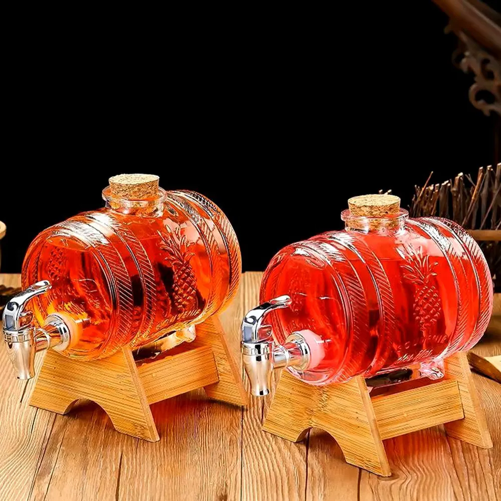 Two glass beverage dispensers with embossed pineapple designs, filled with reddish-orange liquid, on wooden stands with metallic spigots.