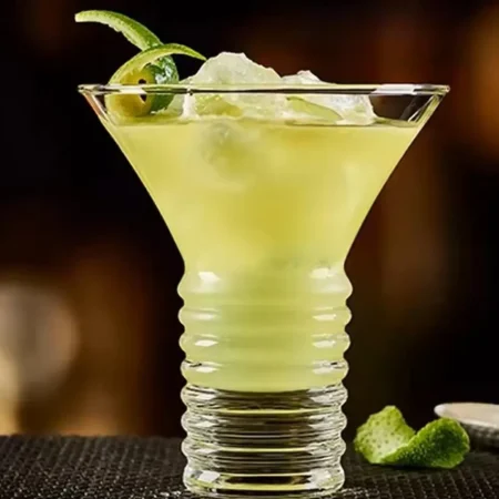 Elegant Twisted Martini Glass featuring an 8 oz capacity with a distinctive spiral stem, filled with a citrus cocktail garnished with lime, on a dark background