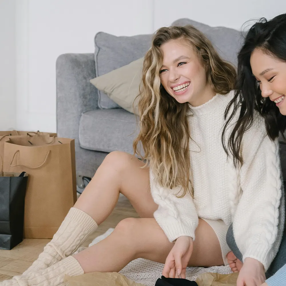 Two individuals happily unboxing a product in a cozy living room, showcasing the joy and assurance of premium drinkware backed by a 100% satisfaction guarantee.