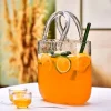 Sip ‘n’ Carry’ handbag-shaped cocktail glass filled with a refreshing citrus drink, garnished with lemon slices and mint leaves.